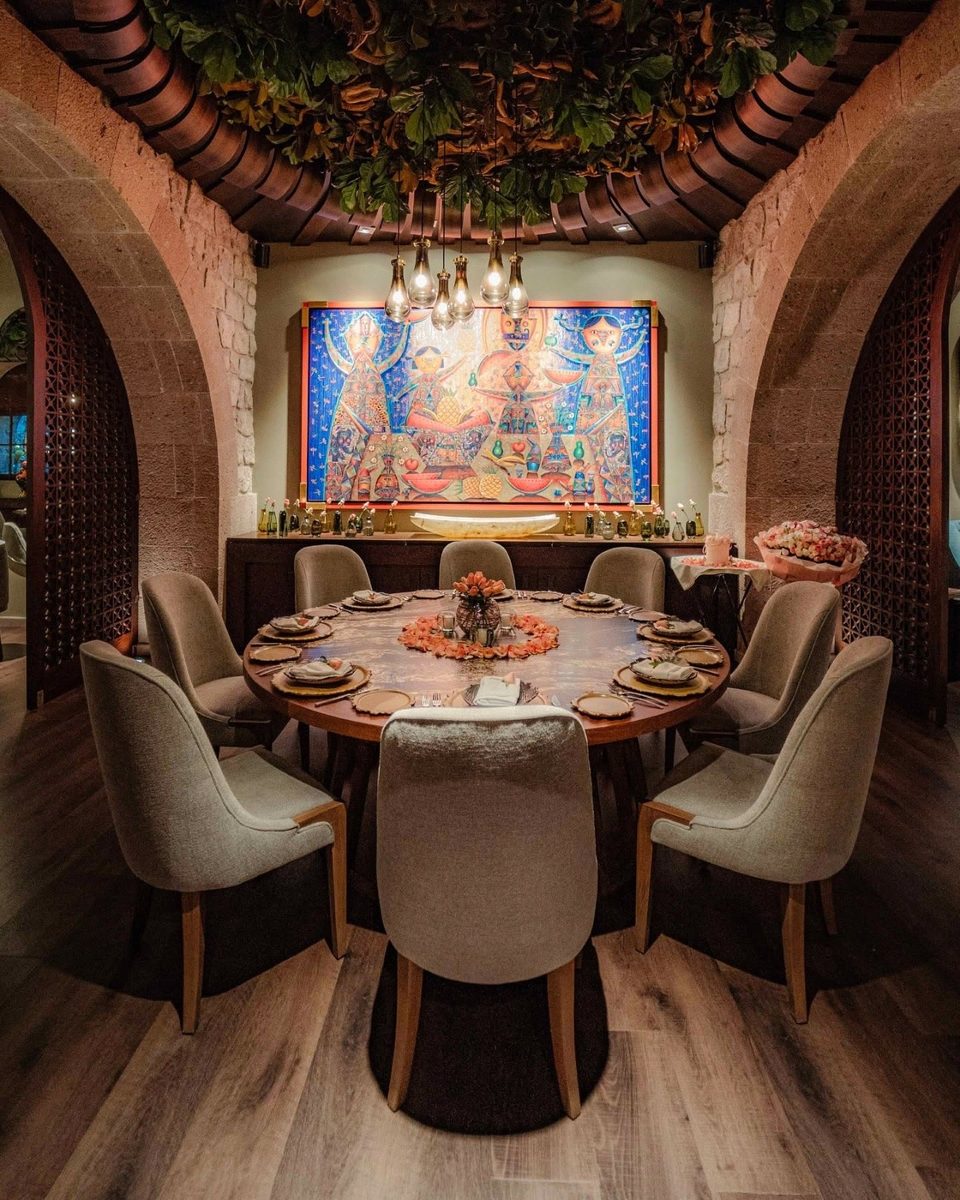 Salón privado con mesa redonda y mural artesanal, Marogui